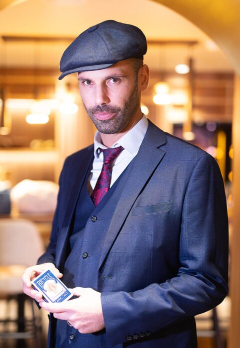 Portrait de Magic Ben en costume trois-pièces avec un jeu de cartes